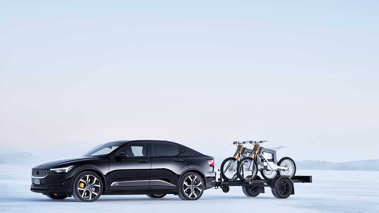 Polestar Sedan towing trailer with bikes in snow